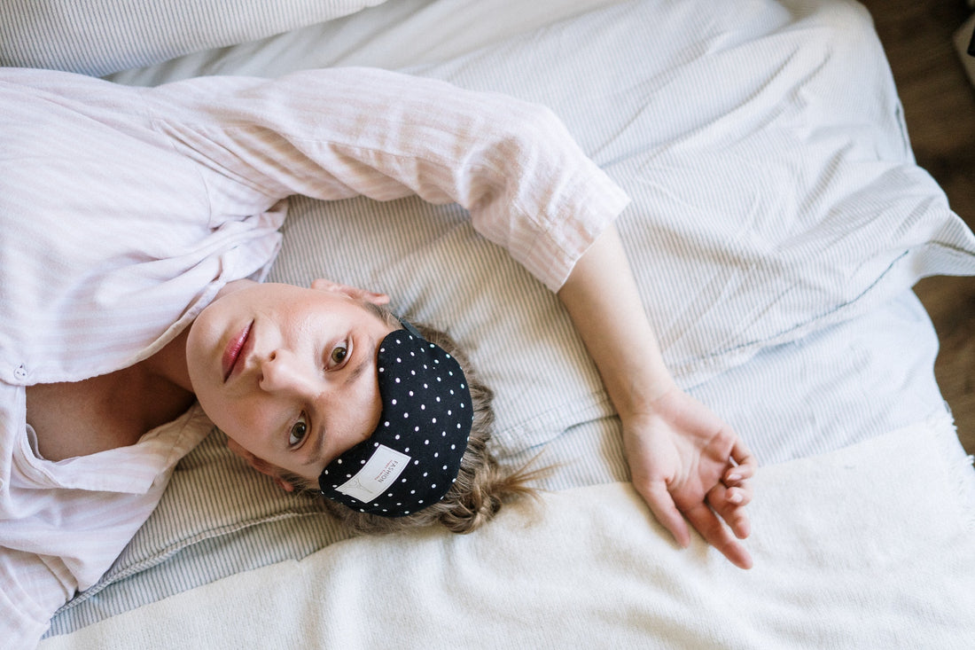 tired woman with eye mask laying in bed