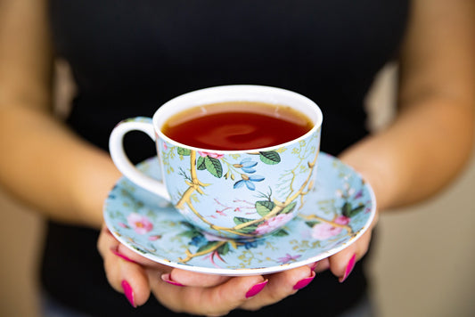 Woman holding a cup of tea and saucer