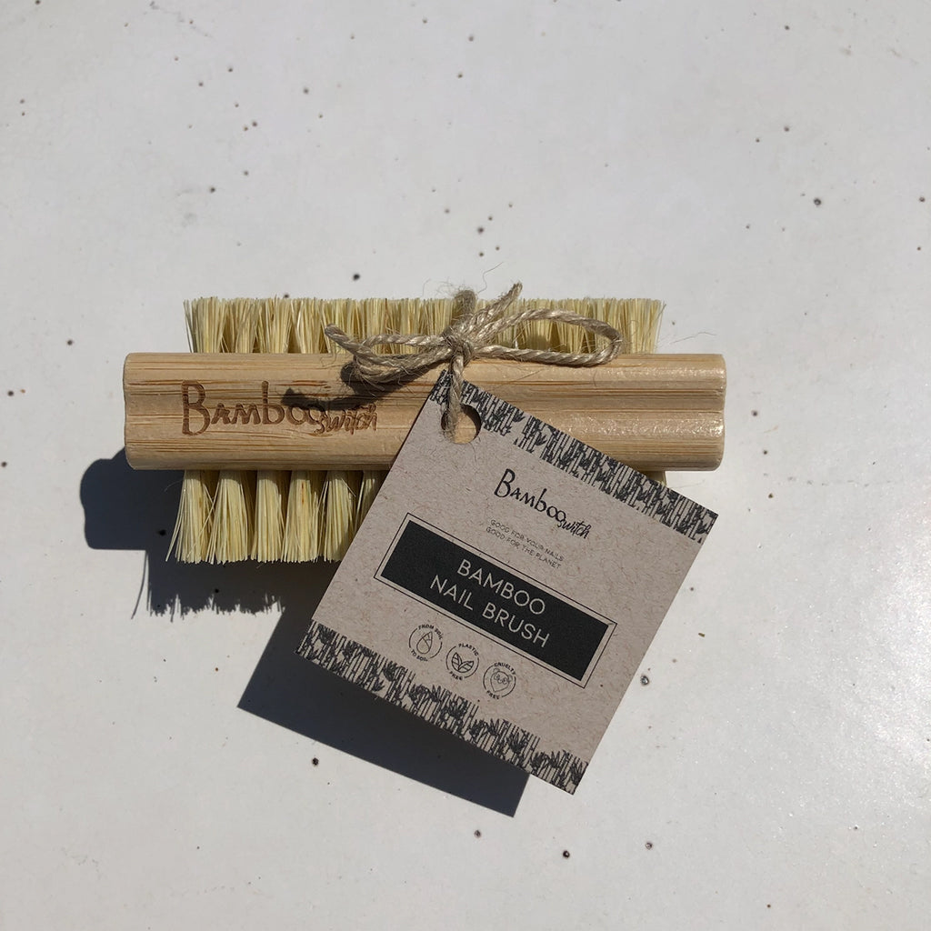 Bamboo nail brush with packaging on a light gray background