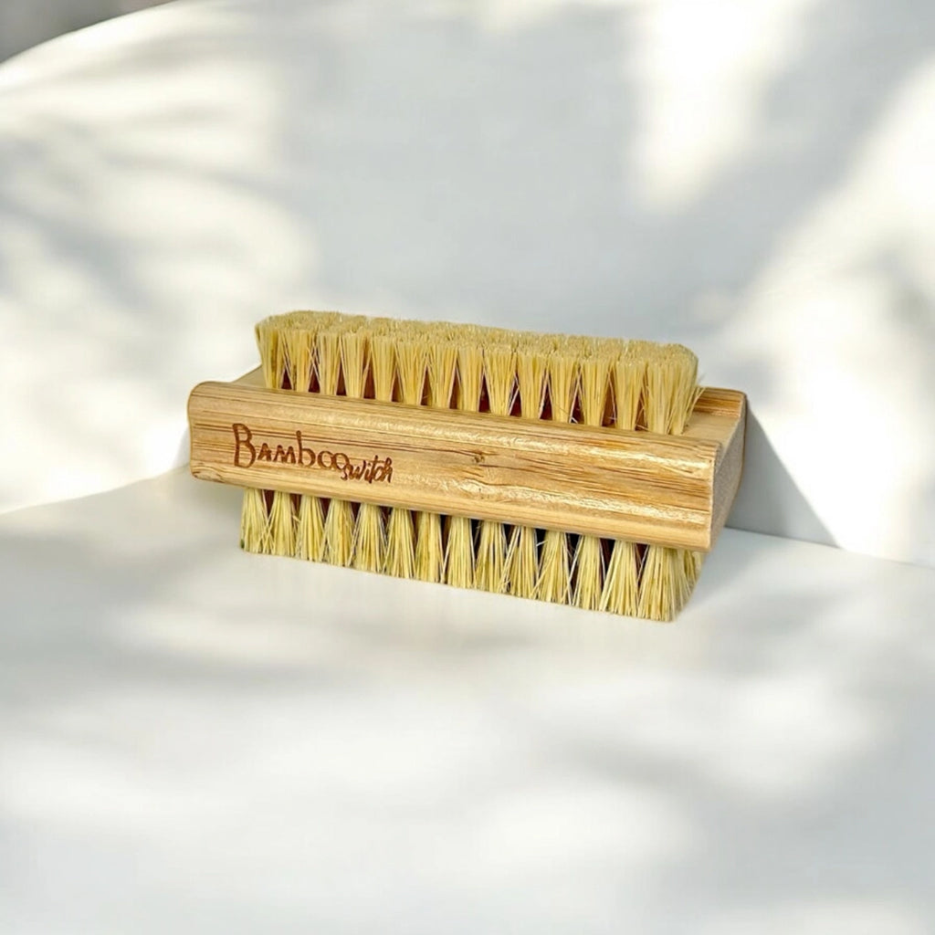Bamboo nail cleaning brush with bristles on a light background