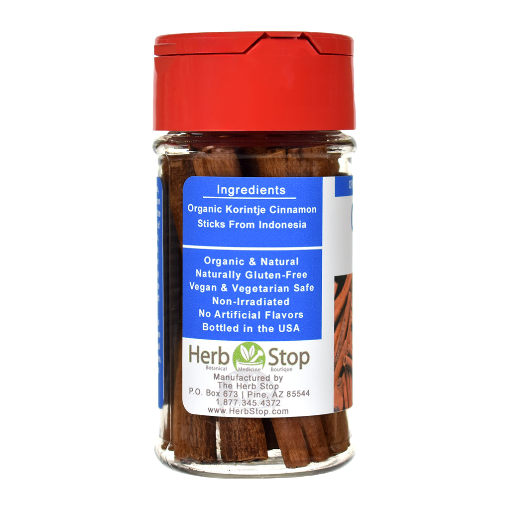 Organic Korintje Cinnamon Sticks in a spice jar with a red lid on a white background