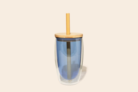 Blue insulated glass tumbler with a bamboo lid and straw