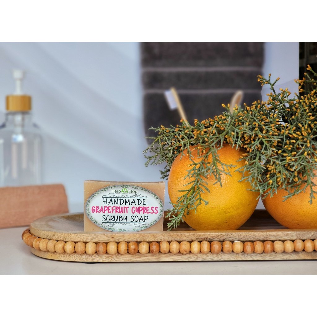 Grapefruit Cypress Soap on a wooden tray with grapefruits and cypress leaves