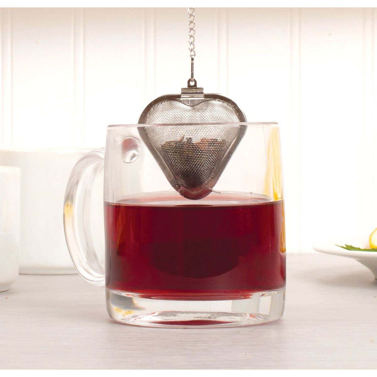 Heart-shaped tea infuser in a mug of red tea