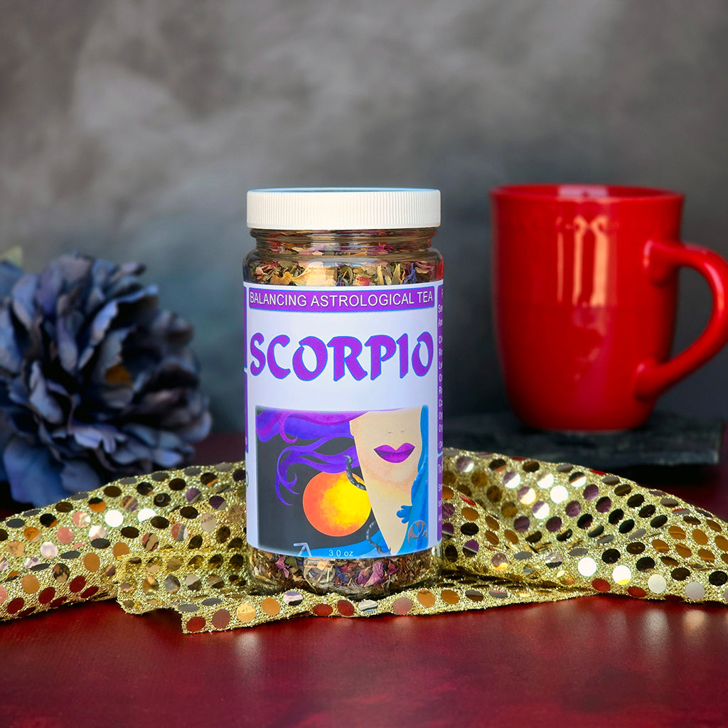 Jar of Scorpio astrological tea with a red mug and decorative elements on a red surface.
