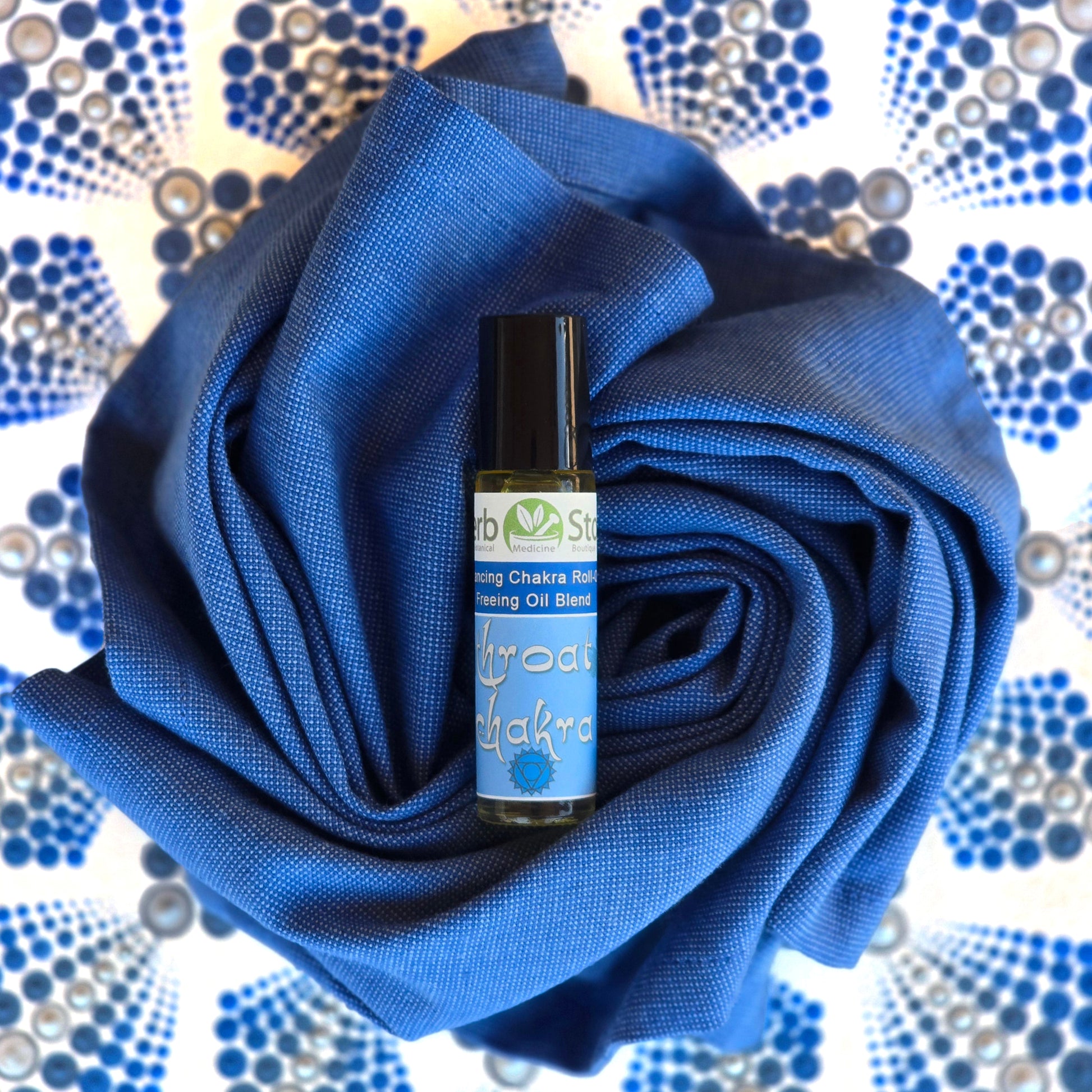 Throat Chakra Aromatherapy Roll-On on a blue cloth with a mandala background
