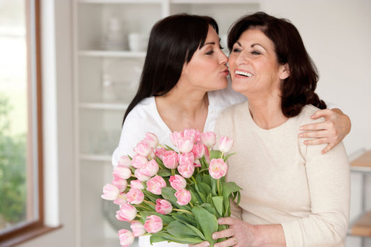 Daughter surprising her mother with pink tulips for Mother’s Day celebration