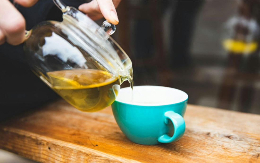 Pouring tea into a blue tea cup