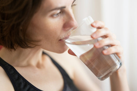 Woman drinking water for gut health and natural cleansing support