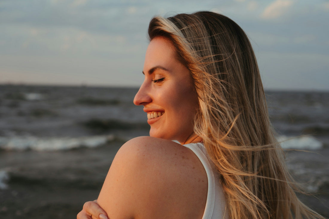 Smiling woman enjoying the ocean breeze during a refreshing fall detox reset