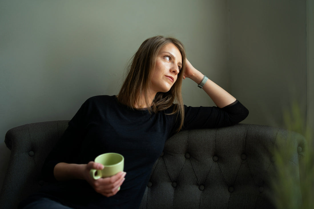 Woman sitting awake in the morning feeling tired and overwhelmed, illustrating the effects of elevated cortisol levels