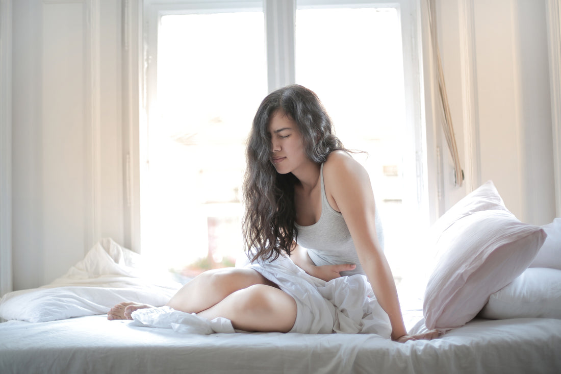 Woman laying in bed with menstrual cramps