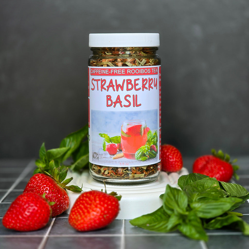 Strawberry Basil Rooibos Tea on a dark background with strawberries and basil leaves nearby