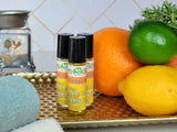 New Beginnings Essential Oil Roll-On next to citrus on a gold tray