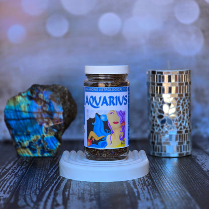 Jar of Aquarius astrological tea on a white surface with decorative elements.