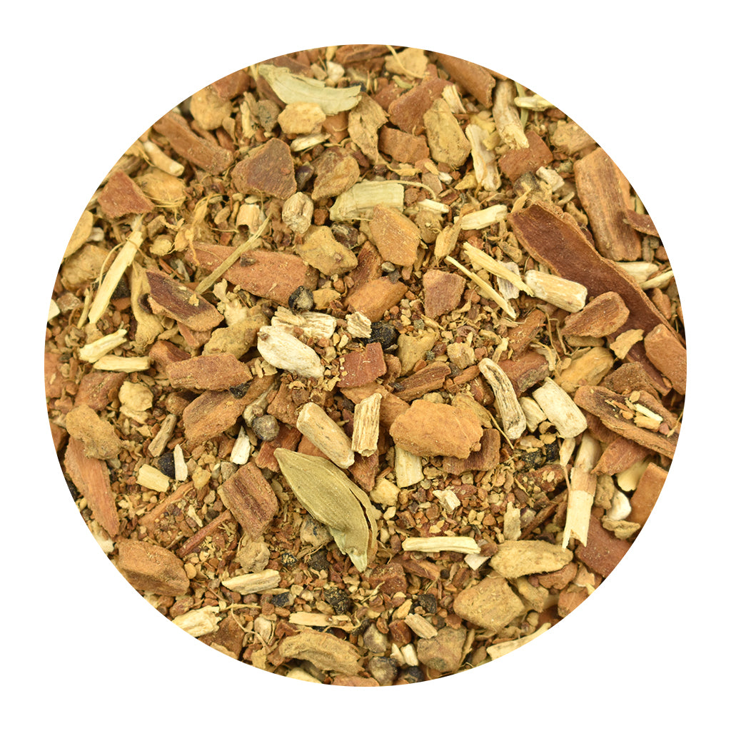A close-up of Ashwagandha Chai loose herbal tea made of cinnamon bark pieces, cardamom, and ginger, centered on a white background.