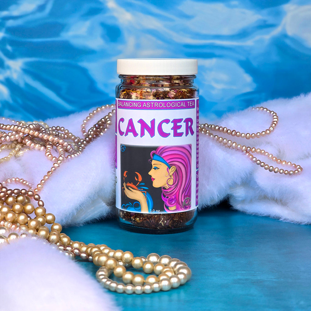 Jar of Cancer astrological tea with decorative pearls and fur on a blue and water background