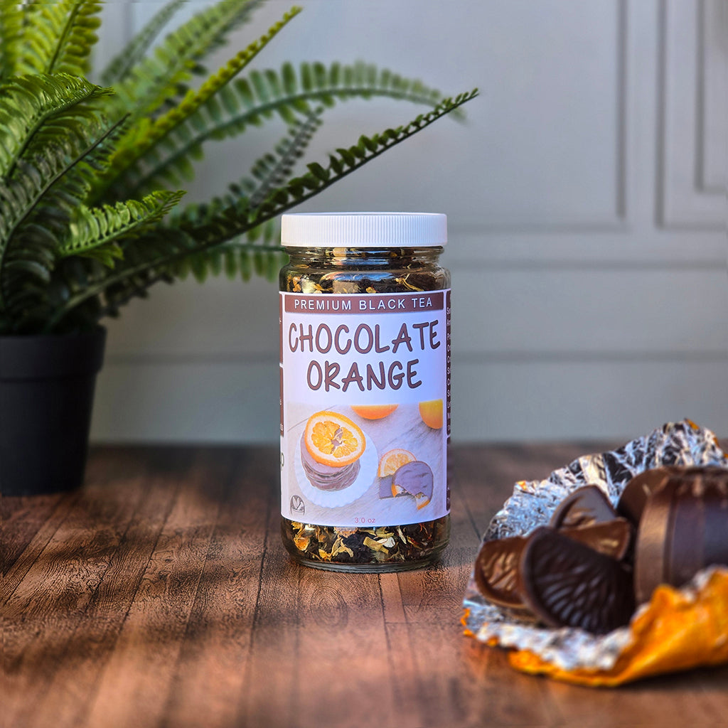 Jar of Chocolate Orange Black Tea on a wooden surface with a plant in the background