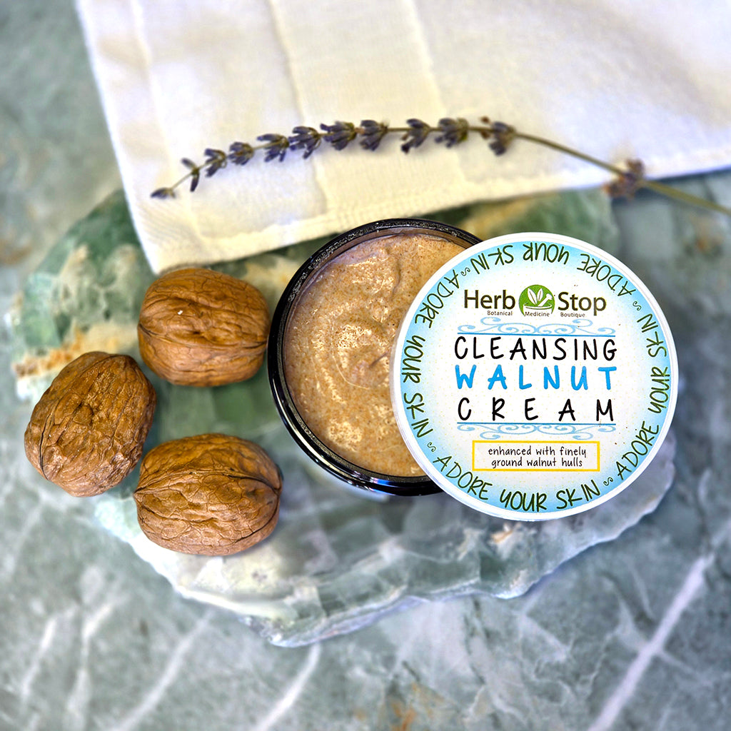 Cleansing Walnut Cream container with walnuts and lavender on a marble surface