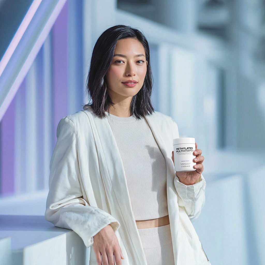 Woman holding Codeage Methylated Multivitamin+ with a blurred background