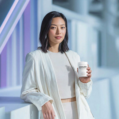Woman holding Codeage Methylated Multivitamin+ with a blurred background