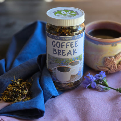 Coffee Break Herbal Tea on a purple tablecloth with chicory flowers and a teacup with tea surrounded by a blue napkin.