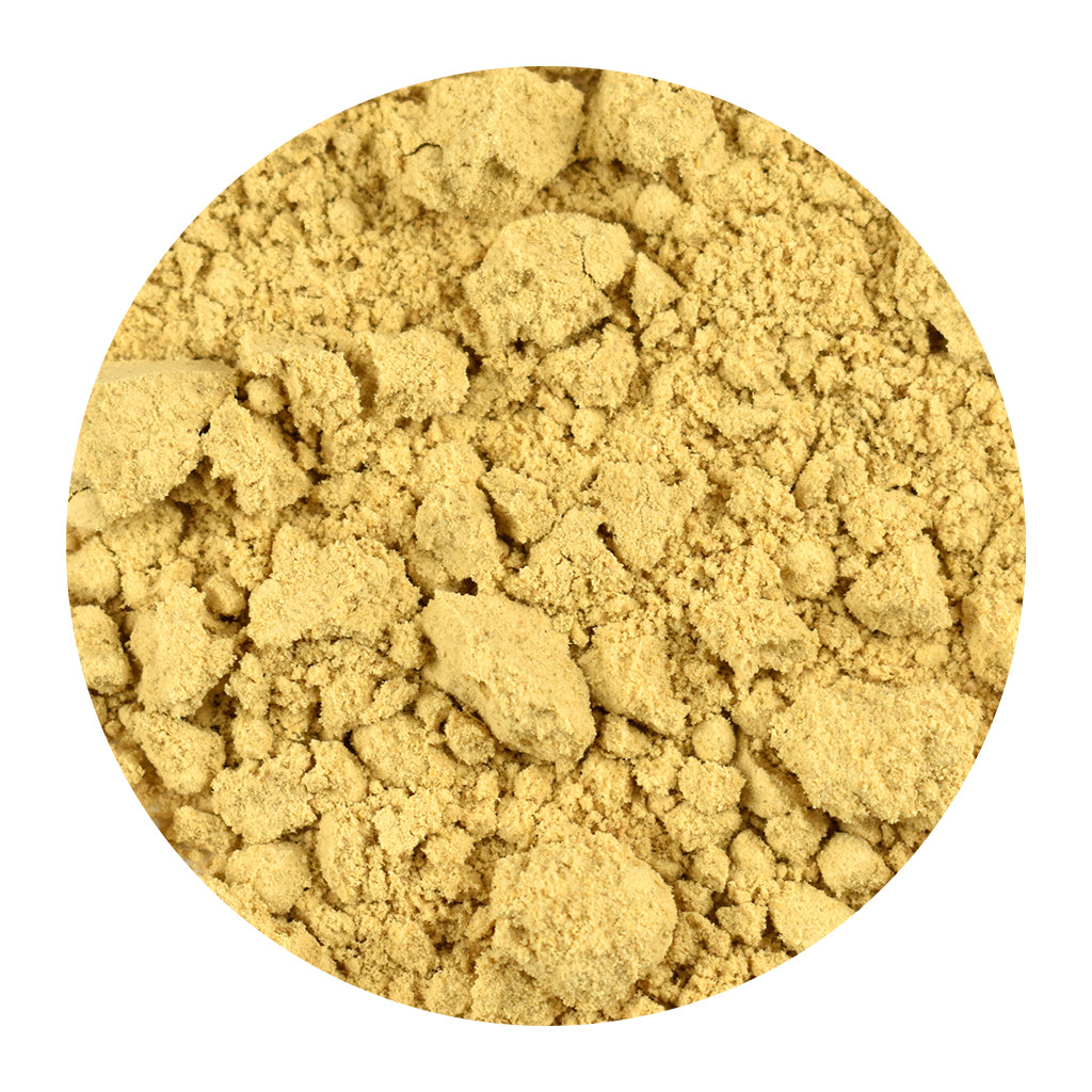 Close-up of bulk ginger root powder on a white background