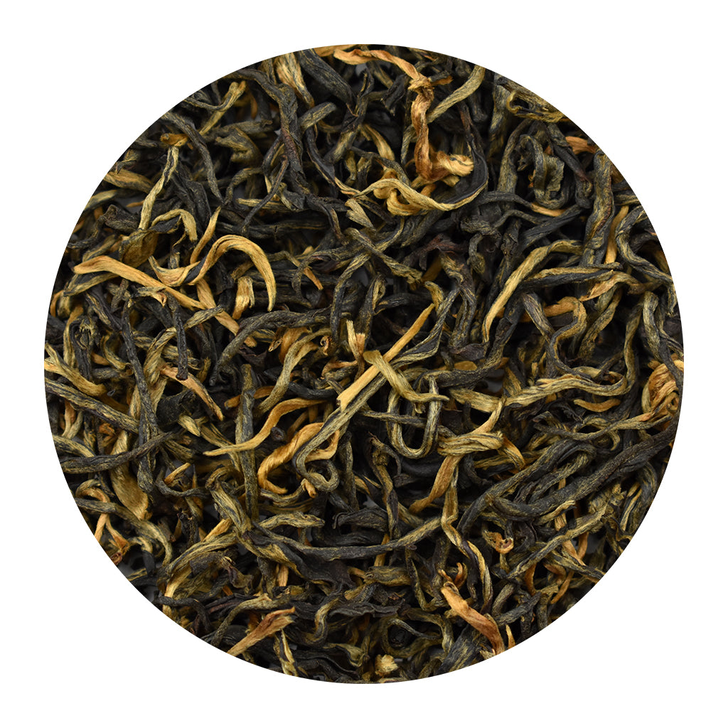A circular close-up of golden monkey loose-leaf black tea leaves, showing dark brown to black rolled leaves mixed with lighter golden-brown and tan tips, isolated on a white background.