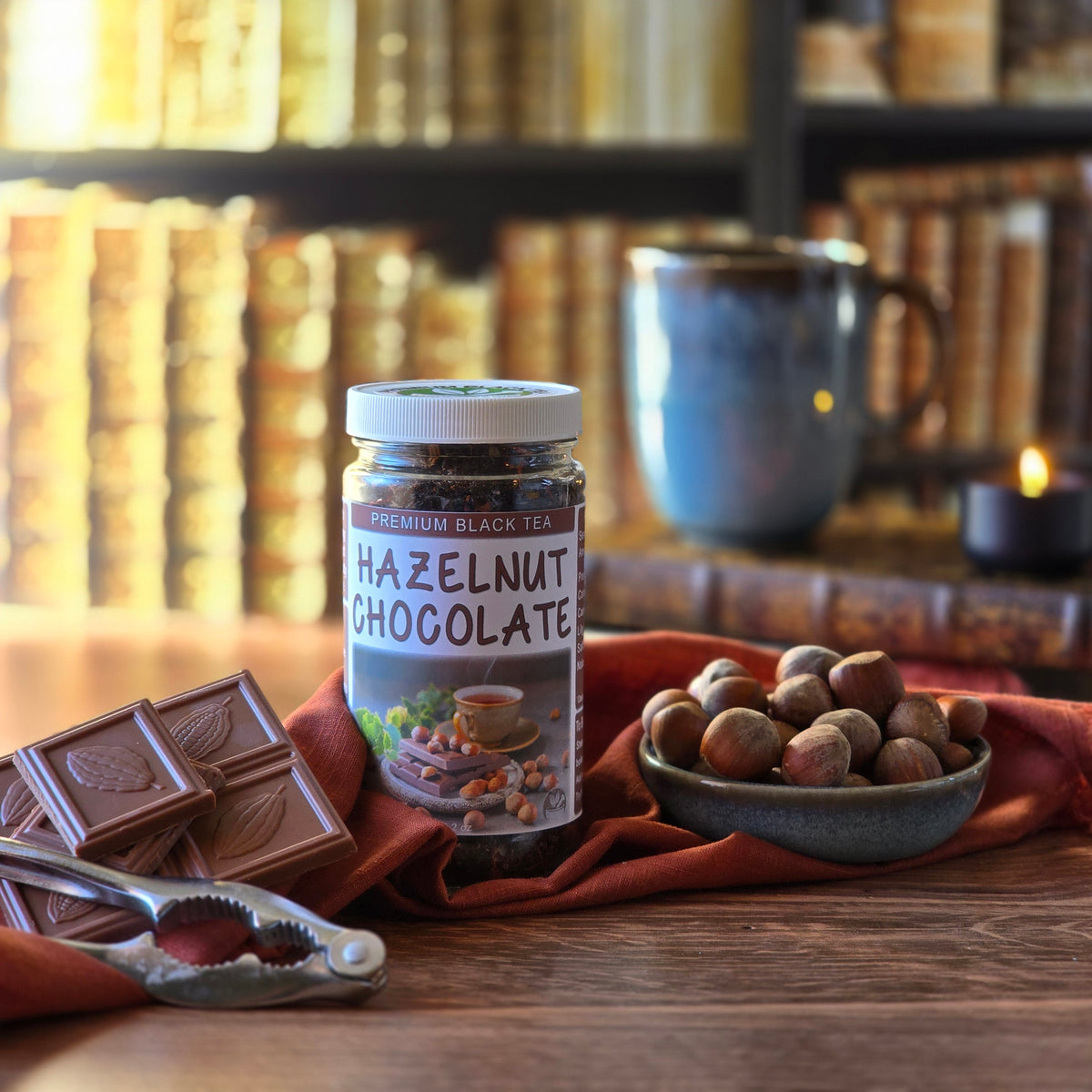Jar of Hazelnut Chocolate Black Tea in a library setting with chocolate and hazelnuts on a wooden surface