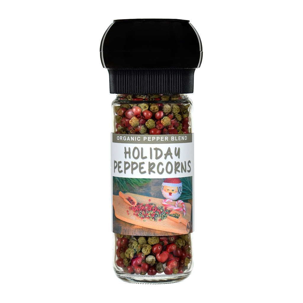 Jar of holiday peppercorns with a grinder lid on a white background