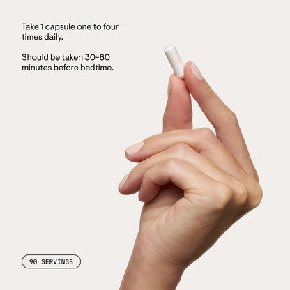 Hand holding a white capsule with supplement instructions on a light background