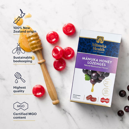 Manuka Health Manuka Honey Lozenges packaging with honey dipper and red lozenges on a marble background