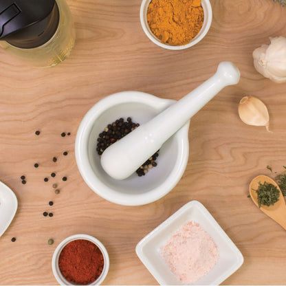 Mortar and pestle with spices on a wooden surface