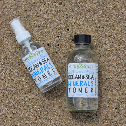 Bottles of Herb Stop Ocean & Sea Minerals Toner in the ocean sand