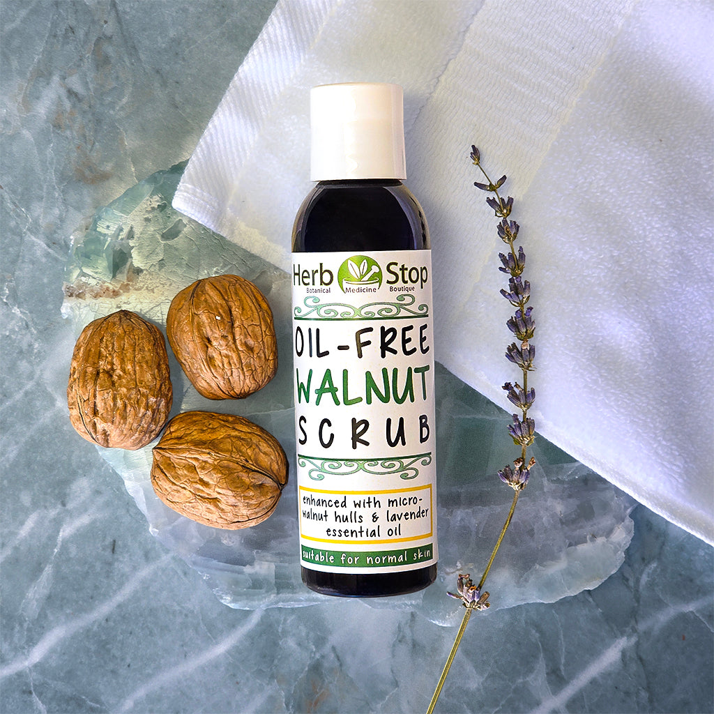 Bottle of Herb Stop Oil-Free Walnut Scrub with walnuts and lavender on a marble surface