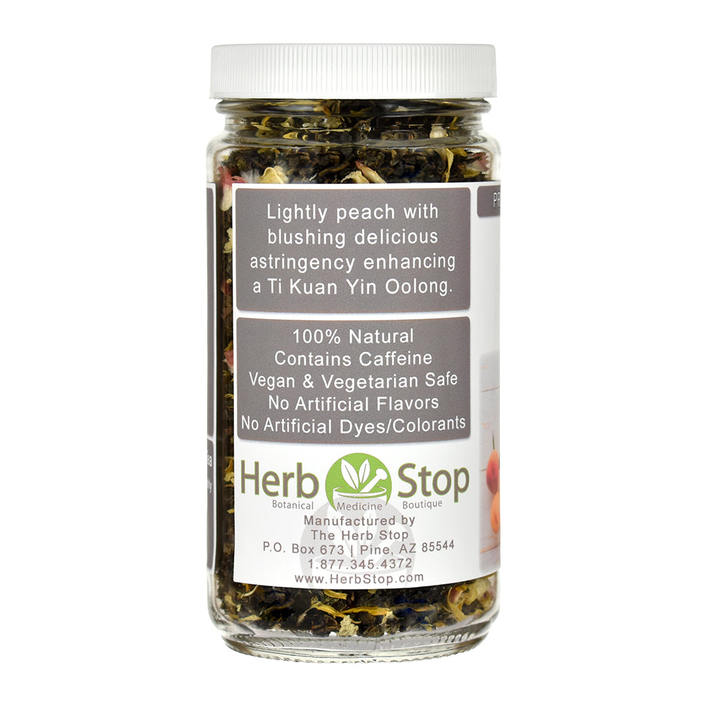 A jar of Herb Stop Peach Oolong Tea with a white lid and a white label, containing dried green tea leaves, on a white background.