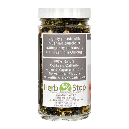A jar of Herb Stop Peach Oolong Tea with a white lid and a white label, containing dried green tea leaves, on a white background.