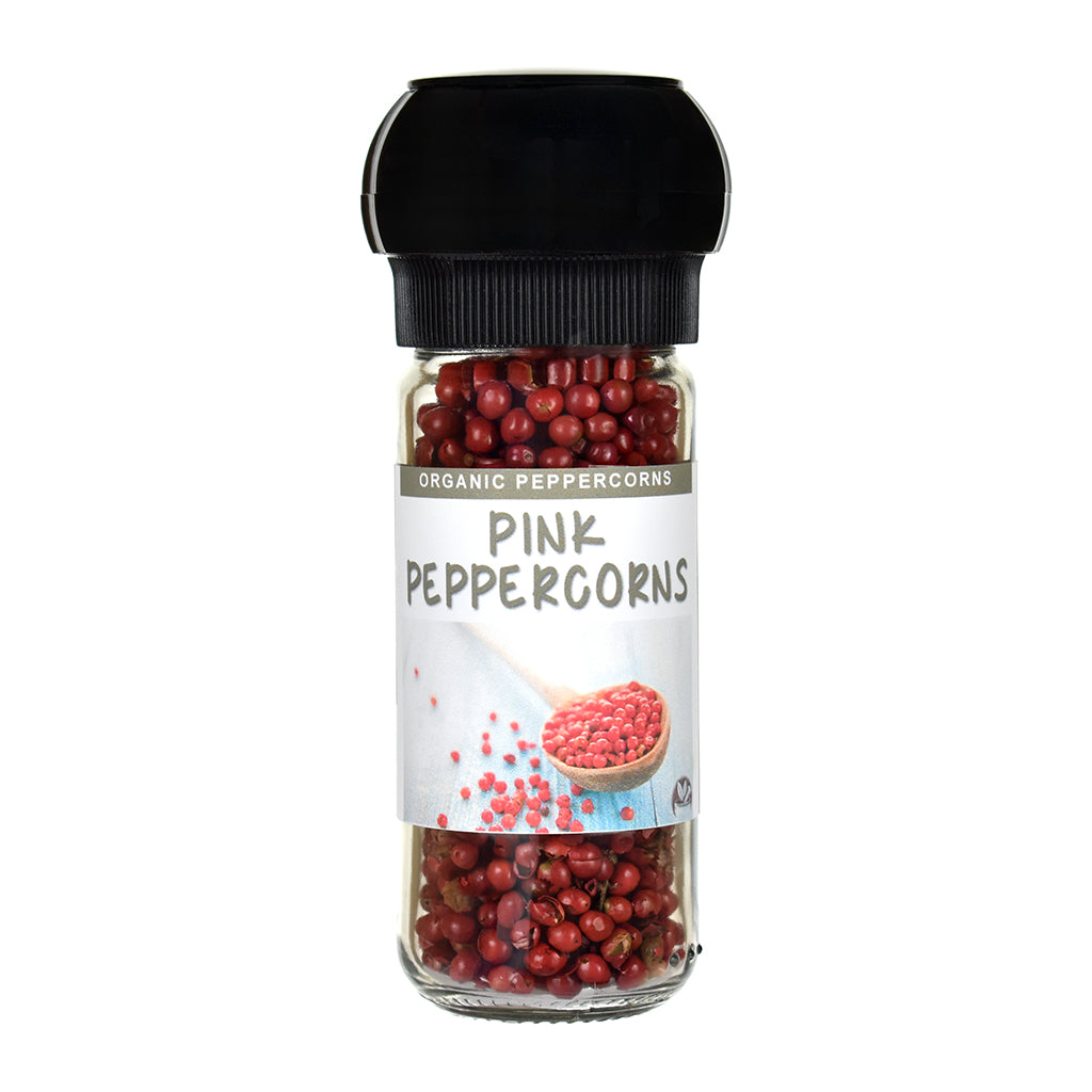 Jar of pink peppercorns with a black  grinder lid on a white background