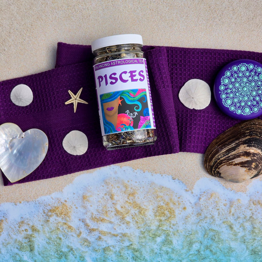 Pisces astrological tea jar on a purple cloth with beach elements