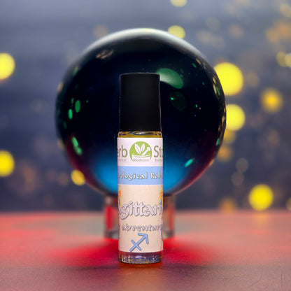 Sagittarius Roll-on Aromatherapy bottle in front of a blue obsidian crystal with blurred lights