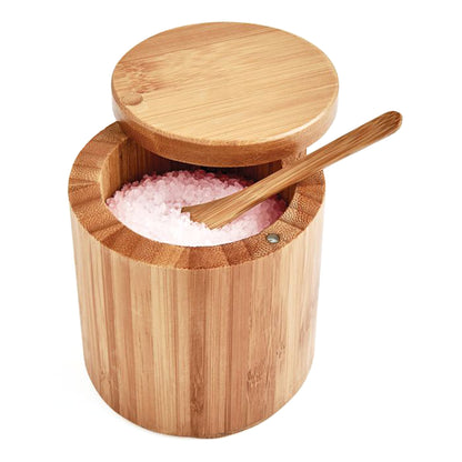 Wooden salt container with pink salt and a wooden spoon on a white background