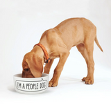 Puppy eating from a I'm A People Dog bowl