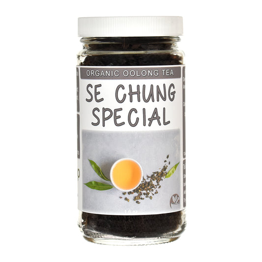 A glass jar of Se Chung Special Organic Oolong Tea with a white screw cap and a gray label featuring a tea leaf illustration and a cup of tea.