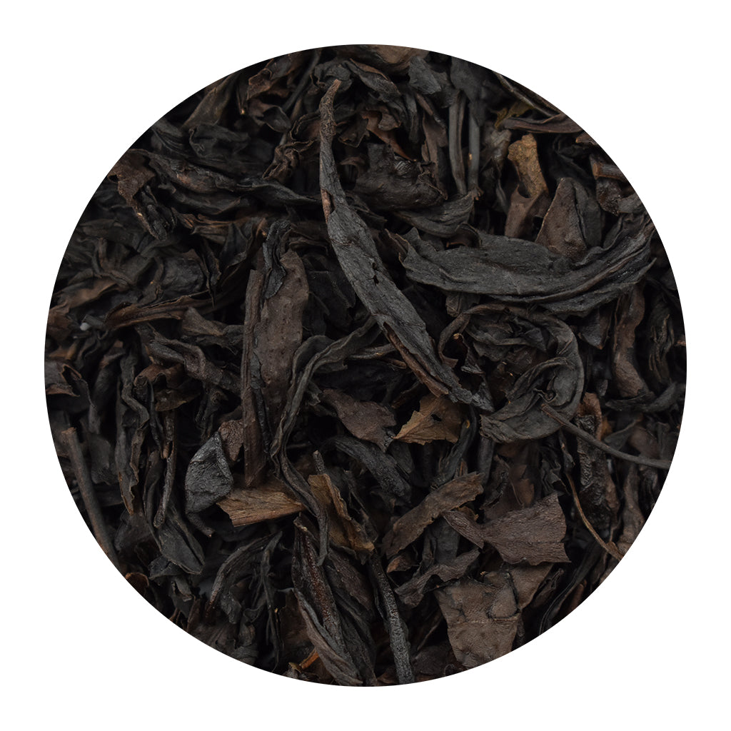 A circular close-up of dark, dried Se Chung Special Oolong loose leaf tea leaves, shown on a plain white background.