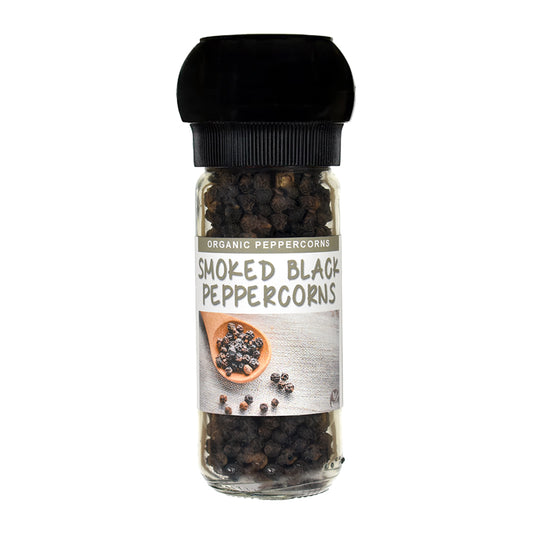 A clear glass spice jar filled with smoked black peppercorns, featuring a black grinder cap and a white label that reads 'SMOKED BLACK PEPPERCORNS' and 'ORGANIC PEPPERCORNS'.