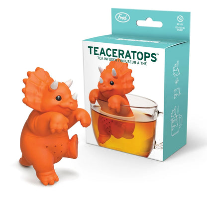 Orange dinosaur-shaped tea infuser with packaging on a white background