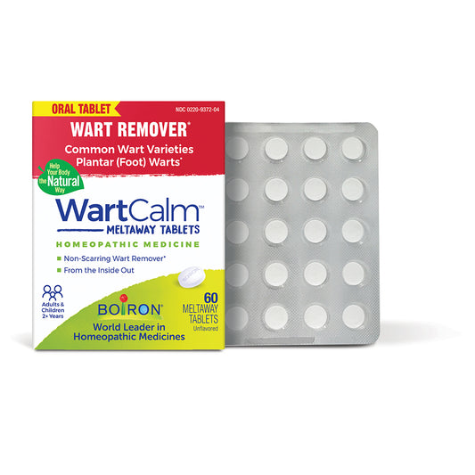 WartCalm Meltaway Tablets homeopathic medicine box next to a silver blister pack containing round white tablets, on a white background.