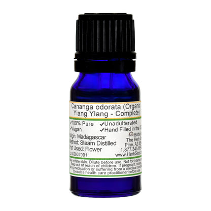 Blue bottle of ylang ylang complete essential oil with a label on a white background