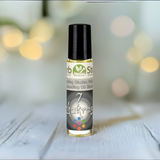 7 Chakras Aromatherapy Essential Oil Roll-On on a wooden surface with bokeh