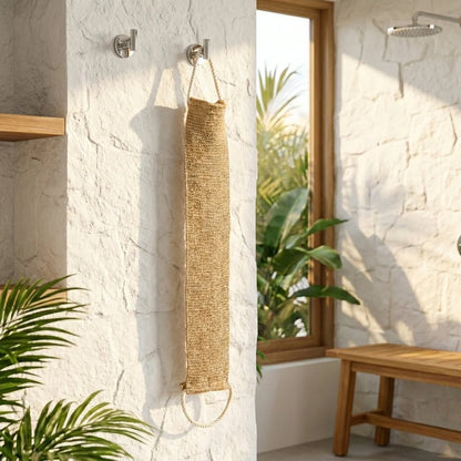 Sisal Back Strap hanging on a wall in a bright bathroom with plants and a bench.